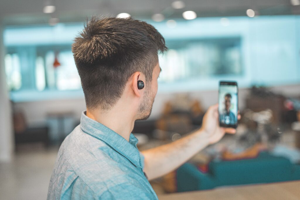 A man doing a Live on his phone. If you need ideas for New Year's marketing campaigns, start thinking about what you could do for a live, or how you could promote your New Year's marketing campaigns via lives.